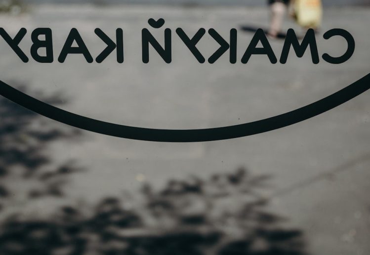 a close up of a sign with a person walking in the background