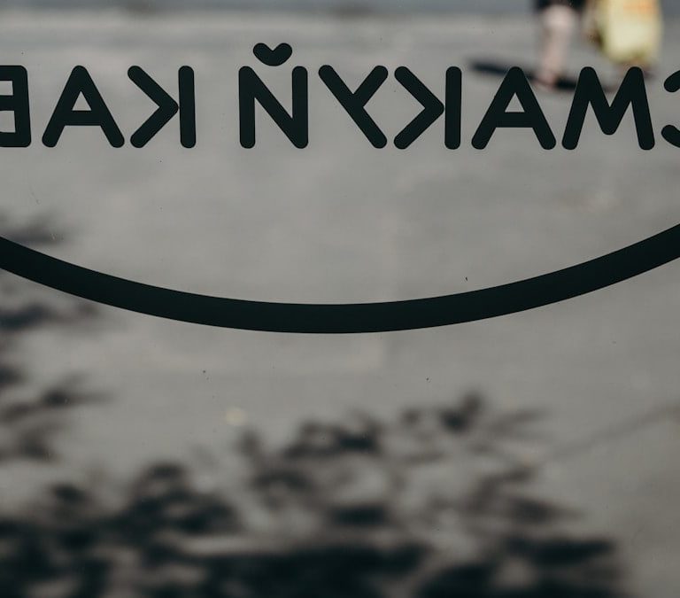 a close up of a sign with a person walking in the background